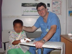 צילום דר אורון עם ילד שנפצע בכף יד